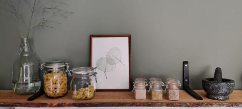 a shelf with jars and a picture and a frame at Cent Trente in Durbuy