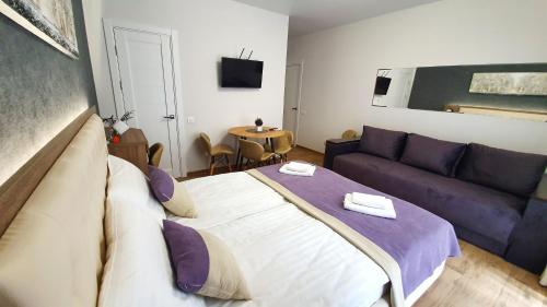 - une chambre avec un grand lit et un canapé dans l'établissement DeMar Apart Violet, à Lviv