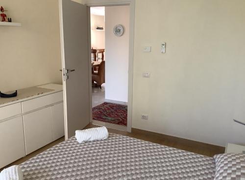 a room with a bed and a door to a kitchen at Colonno Panoramica Lago Di Como in Colonno
