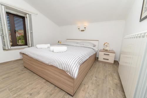 Habitación blanca con cama y ventana en Beautiful Apartment Aleks en Mali Lošinj