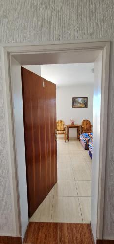 een hal met een deur en een tafel en stoelen bij kurt apartaments in Ulcinj