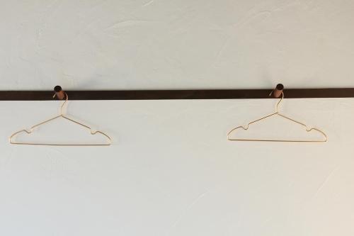 two metal hangers hanging on a white wall at 淡路島西海岸の宿 梅木屋 in Sumoto