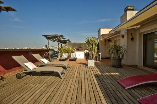 una terraza con tumbonas y vistas al océano. en Los Condes Penthouse by Hello Homes Sitges en Sitges