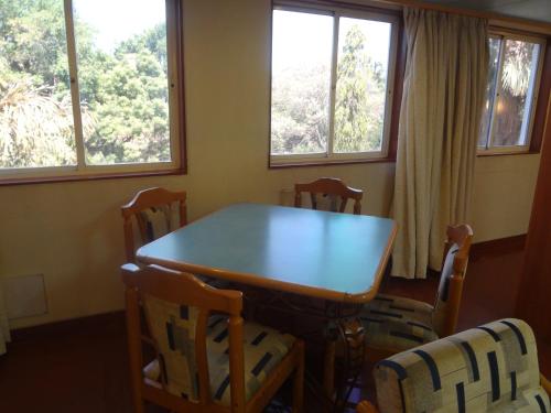 a dining room with a table and chairs and windows at Hotel Shree Panchratna Pune in Pune