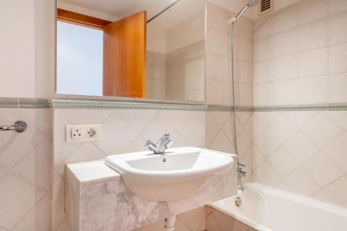 a bathroom with a sink and a mirror and a tub at Talaia Bajos A in Port de Pollensa