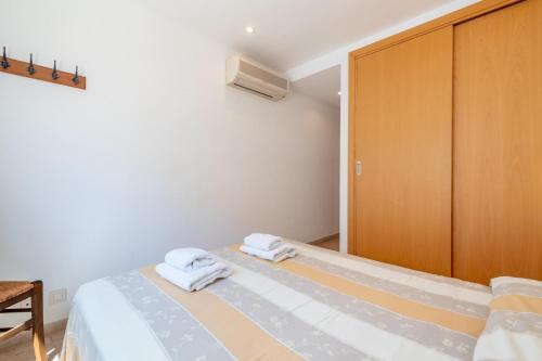 a bedroom with a bed and a wooden cabinet at Talaia Bajos A in Port de Pollensa