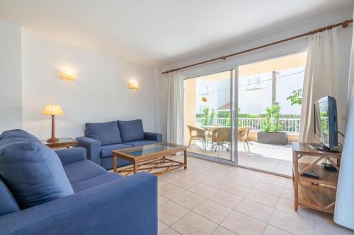 a living room with a blue couch and a tv at Talaia Bajos A in Port de Pollensa