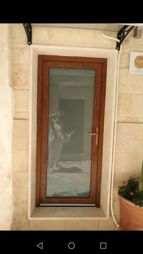 a picture of a man standing in a window at Lithos house pt 1p e 2p in Monopoli