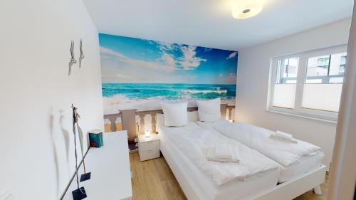 um quarto com uma cama com uma pintura do oceano em Villa Meeresrauschen Wohnung 09 - Lieblingsplatz em Pelzerhaken