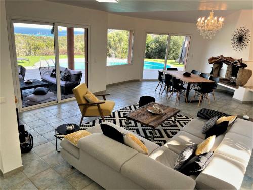 un salon avec un canapé et une table dans l'établissement Villa AZURA, vue panoramique et proche mer à Santa Giulia, piscine chauffée, à Porto-Vecchio