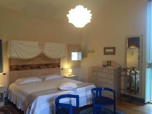 a bedroom with a bed and two blue chairs at La Vittoria 10 – La Soglia della Val d’Orcia in Chianciano Terme