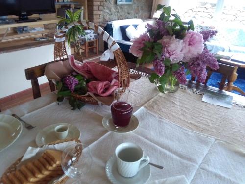 a table with a vase of flowers and a cup of coffee at La Vittoria 10 – La Soglia della Val d’Orcia in Chianciano Terme
