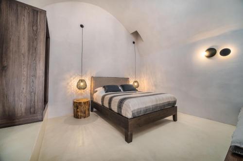 a bedroom with a bed with two lamps on it at Phaos 1870, A restored Winery in Pirgos