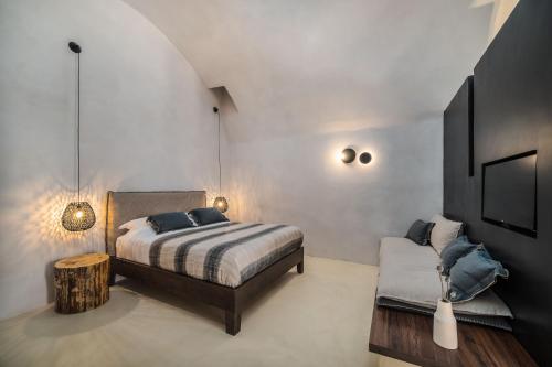 a bedroom with a bed and a couch and a tv at Phaos 1870, A restored Winery in Pirgos