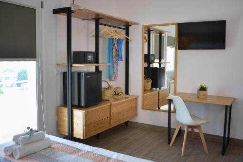 um quarto com uma secretária, uma televisão e uma cadeira em Dimora EFFE - Eco B&B em Termoli