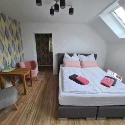a bedroom with a bed with pink pillows on it at Gästezimmer Treuen - Bed & Breakfast in Treuen