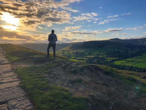 a man standing on top of a hill looking at the sunset at Hollin House Hotel in Macclesfield