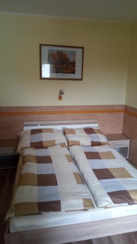 a bed in a room with a picture on the wall at Sifra 276 in Nová Lesná