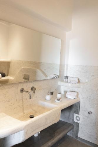 a bathroom with a sink and a tub at Demilmar Luxury Suites in Perissa