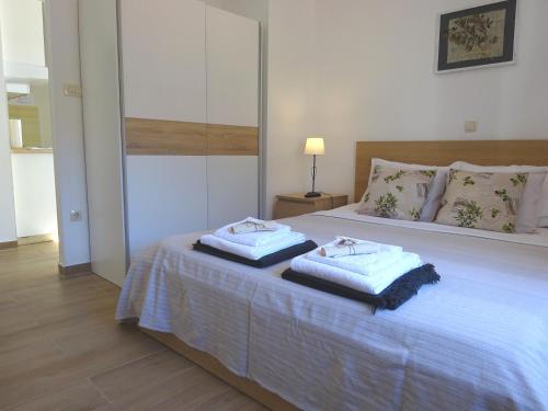 a bedroom with a bed with two towels on it at Eco Apartments Kate in Suđurađ