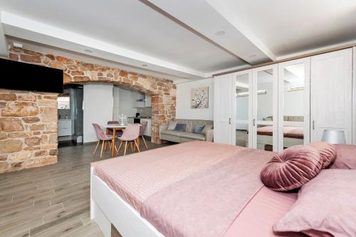 een slaapkamer met een groot bed en een bakstenen muur bij Villa Miracolo in Rovinj