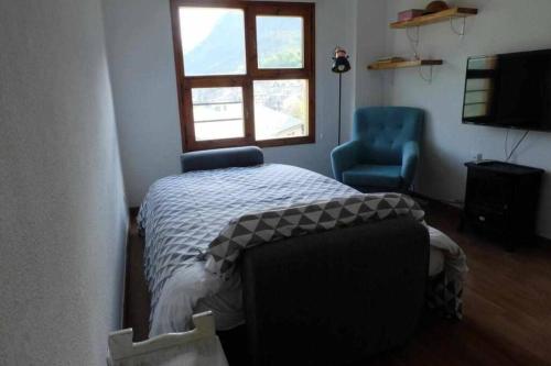 una camera con un letto e una sedia e una finestra di Inmocyma Ibonet-Cerler a Cerler