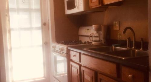 cocina con fregadero, fogones y ventana en Sunset Beach Hotel, en Wildwood