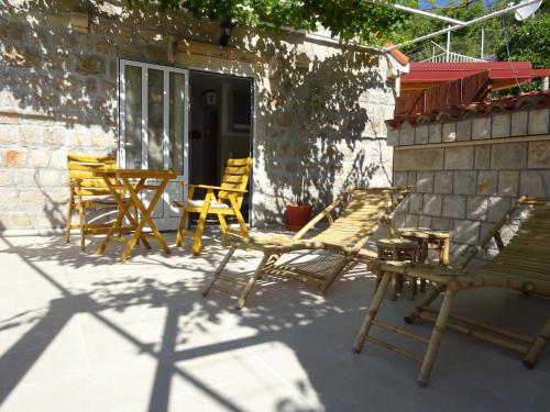 a group of chairs and tables on a patio at Eco Apartments Kate in Suđurađ
