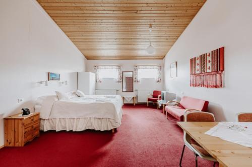 Narfastadir Guesthouse في لاوغار: غرفة نوم بسرير كبير وسجادة حمراء