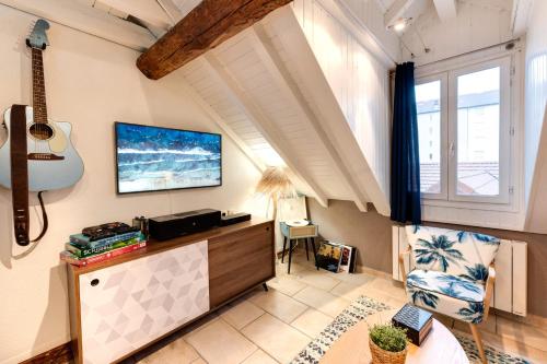 - un salon avec une guitare sur le mur dans l'établissement Carnot on the Roof 2 - 4 personnes Lac at 400m, à Annecy