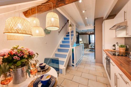 une cuisine avec un escalier et une table fleurie dans l'établissement Carnot on the Roof 2 - 4 personnes Lac at 400m, à Annecy