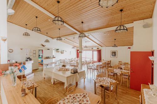 a dining room with tables and chairs and wooden ceilings at Narfastadir Guesthouse in Laugar