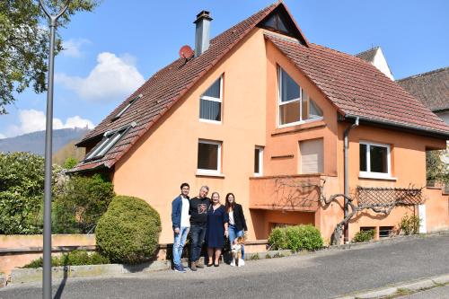 un grupo de personas parados frente a una casa en Chez Max Alsace en Saint-Hippolyte