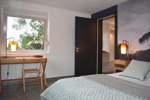 - une chambre avec un lit, un bureau et une fenêtre dans l'établissement Chez Max Alsace, à Saint-Hippolyte
