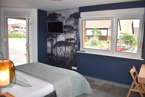 sypialnia z łóżkiem i oknem w obiekcie Chez Max Alsace w mieście Saint-Hippolyte