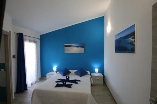 1 dormitorio azul con 1 cama con paredes azules en Guest house Ajo' a mulinu, en Teulada