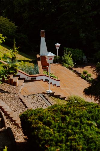 a garden with a bench and a street light at Elita Hotel & Restauracja in Iwonicz-Zdrój