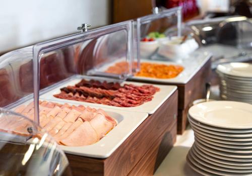 a buffet line with meat and other food items at Hotel Rebstock in Luzern