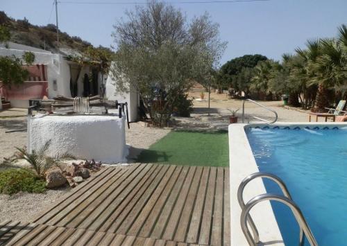 a house with a swimming pool next to a yard at Cortijo casa rural "La cueva " in Almería