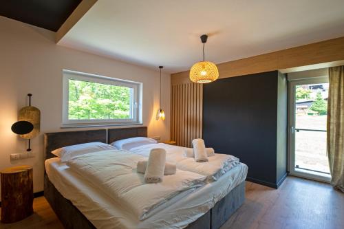 een slaapkamer met een groot bed met 2 witte kussens bij Sun&Sport Apartament GÓRSKIE SZLAKI sauna i parking w cenie in Szczyrk