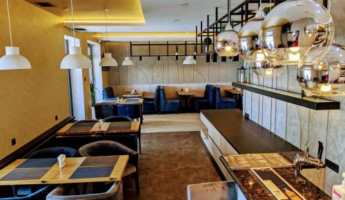 une salle à manger avec des tables, des chaises et des lumières dans l'établissement Kook Hotel & Rest, à Ryasne-Rus'ke
