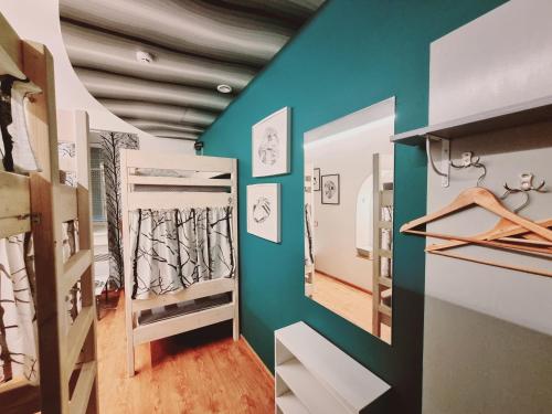 a room with green walls and a hallway with shelves at HelloVilniusHostel in Vilnius