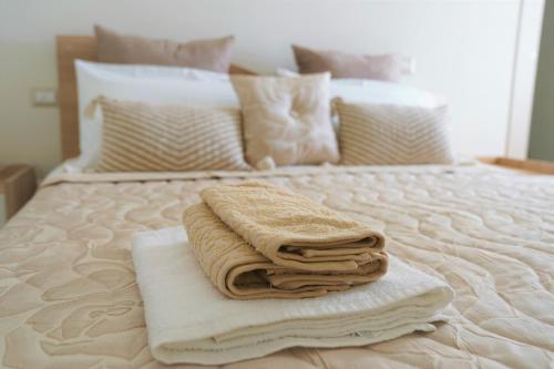 una pila de toallas sentadas encima de una cama en Vesuvius' Lovely Inn, en Ercolano