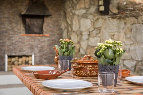 a wooden table with plates and flowers on it at Estrela de Montesinho in Bragança
