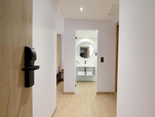 a hallway with a white room with a mirror at UVE Marcenado in Madrid