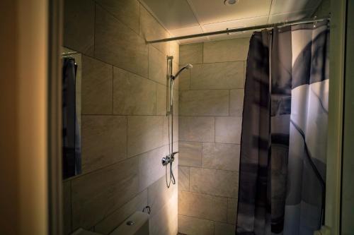 a bathroom with a shower with a shower curtain at Къщички Синьо лято, Черноморец - Варна - Blue Summer Houses Varna in Varna City