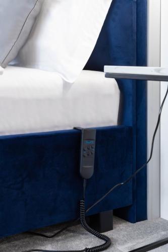 a bed with a phone plugged into a blue wall at Kayus in Buşteni
