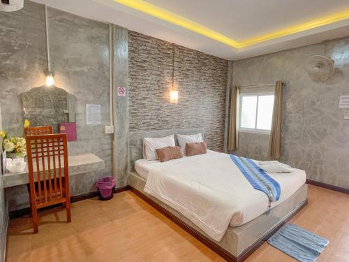 una camera con un grande letto e un bagno di โรงแรมโทนี่วิลเลจTony Hotel a Phatthalung