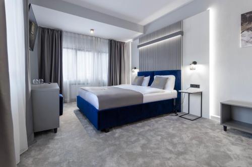a hotel room with a bed and a bathroom at Kayus in Buşteni