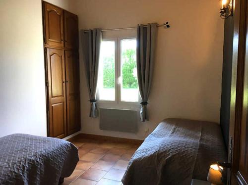 1 dormitorio con cama y ventana en Ferme Para Lou en Sainte-Croix-du-Verdon